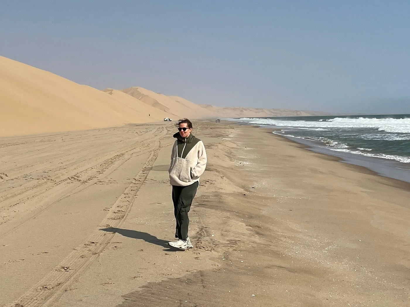 A guest standing between the dunes and ocean