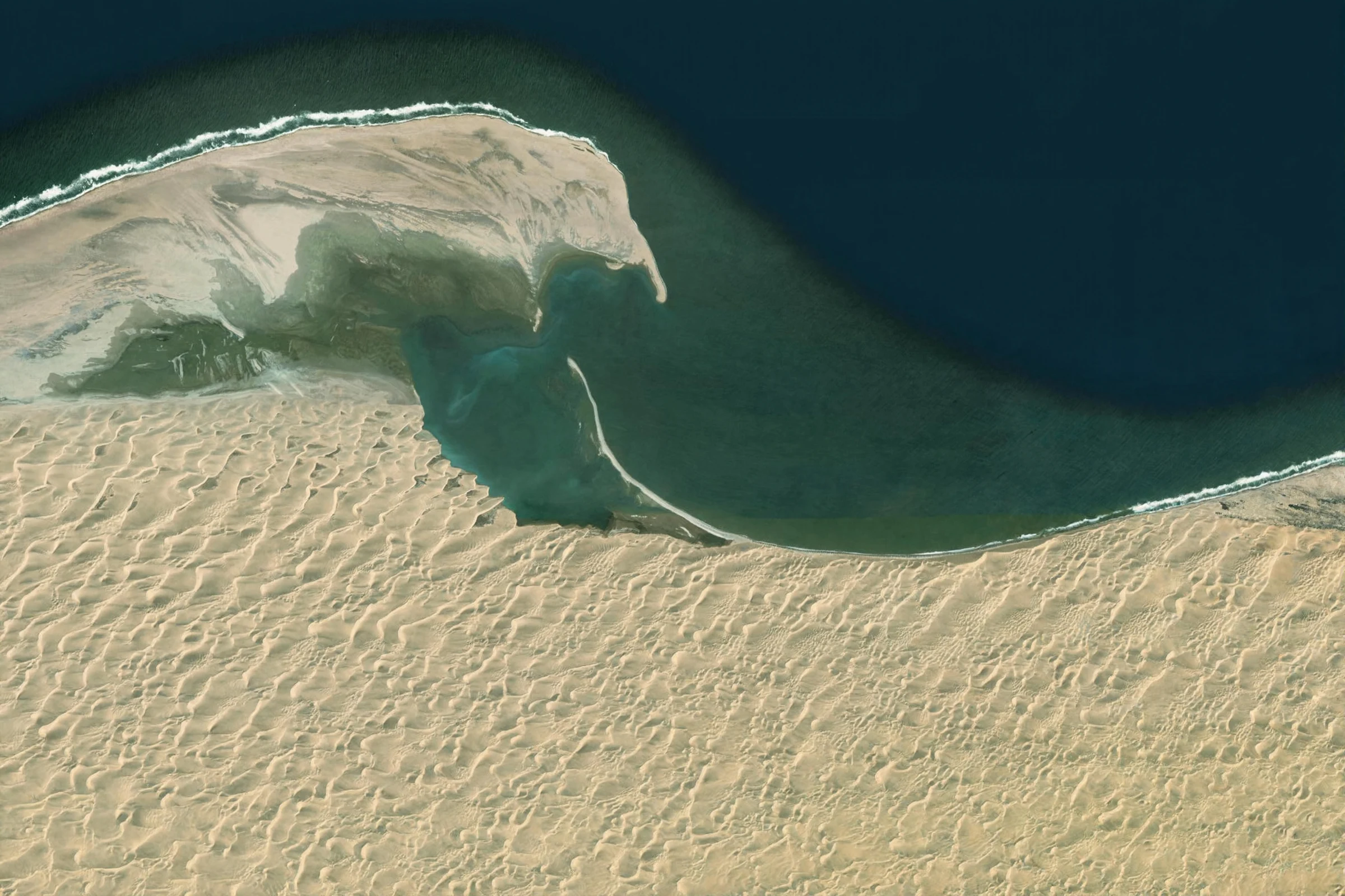 Overhead view of a coastal lagoon, sand dunes and the ocean at Sandwich Harbour